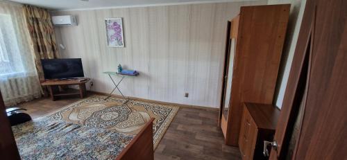 a small room with a bed and a television at Однокомнатная квартира в Караганде in Karagandy