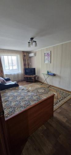 Однокомнатная квартира в Караганде في كاراغاندي: غرفة معيشة مع سجادة كبيرة على الأرض