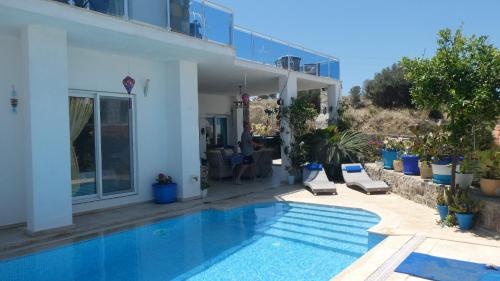 eine Villa mit einem Swimmingpool vor einem Haus in der Unterkunft Villa Priene - Gumusluk Private Pool in Gümüşlük