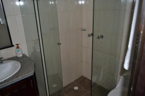 a shower with a glass door next to a sink at Casa de la Ciencia in Salento