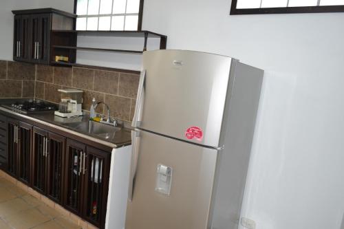 a white refrigerator in a kitchen next to a sink at Casa de la Ciencia in Salento