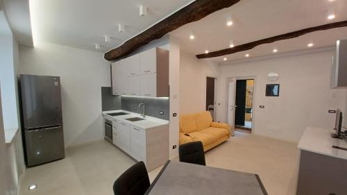a kitchen and a living room with a yellow couch at Residenza il Gelsomino in Cantello
