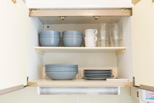 a pantry with blue bowls and plates on shelves at Kami Inn in Tokyo