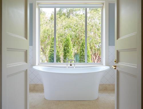 a bath tub in a bathroom with a window at Le Mas Barossa in Rowland Flat