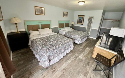 a hotel room with two beds and a flat screen tv at Alaska Angler's Inn in Soldotna