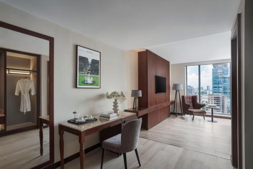 a hotel room with a desk and a chair at Signature by M Village Lê Thánh Tôn in Ho Chi Minh City