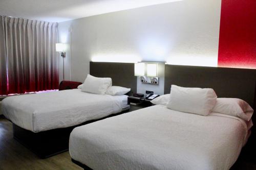 una habitación de hotel con 2 camas y una raya roja en la pared en Ramada by Wyndham Harrisonburg, en Harrisonburg
