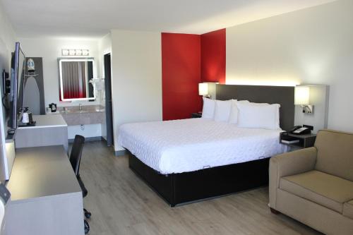 a hotel room with a large bed and a bathroom at Ramada by Wyndham Harrisonburg in Harrisonburg