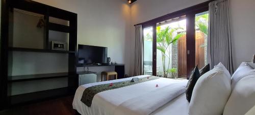 a bedroom with a large white bed with a window at The Trawangan Resort in Gili Trawangan
