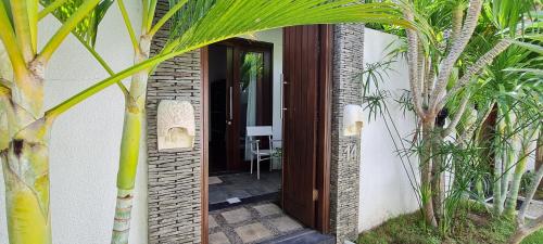 an open door of a house with palm trees at The Trawangan Resort in Gili Trawangan