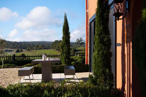 a patio with a table and chairs in a yard at Villa Monte Lago in Glenlyon
