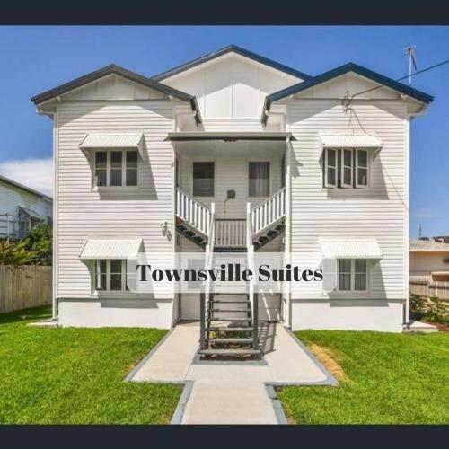 a white house with the words townsville suites on it at Townsville Suites in Townsville