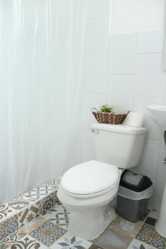a white bathroom with a toilet and a sink at Real Hostal in Guatemala