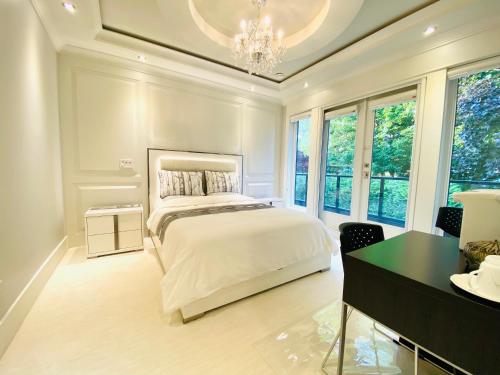 a bedroom with a bed and a desk and windows at Vancouver Shangrila House in Richmond