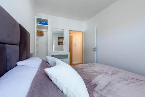 a bedroom with a large bed with white sheets at Apartament Modern by Major Domus Club in Dziwnów
