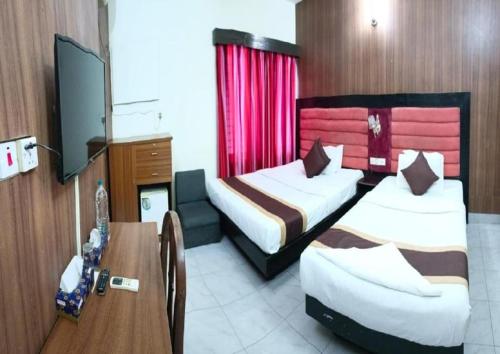 a hotel room with two beds and a table at Hotel Skylink in Dhaka