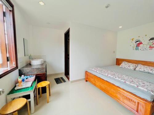 1 dormitorio con 1 cama, mesa y sillas en Kenppi HOMESTAY, en Hue