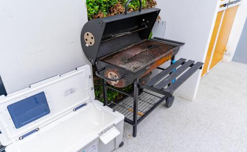 a barbecue grill with a bench next to a plant at Villa Paramount 1 in Nakhon Nayok