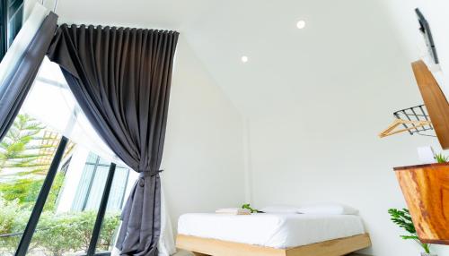 a bedroom with a bed and a large window at Villa Paramount 1 in Nakhon Nayok