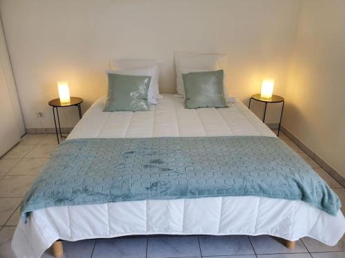 um quarto com uma cama grande e 2 candeeiros em Appartement Le Boïate YourHostHelper em La Teste-de-Buch