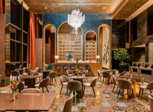 a restaurant with tables and chairs and a chandelier at 8 Kia Peng Suites Residence in Kuala Lumpur