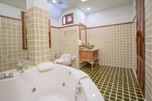 ein Badezimmer mit einer Badewanne, einem WC und einem Waschbecken in der Unterkunft Rich Garden House Hotel in Chiang Mai
