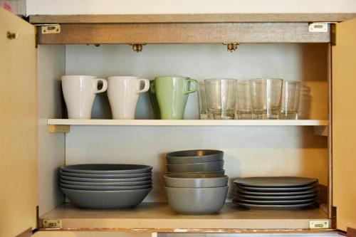een kast gevuld met borden, bekers en kommen bij KAMINARI Inn Newly Renovated Jan 2026 in Tokyo