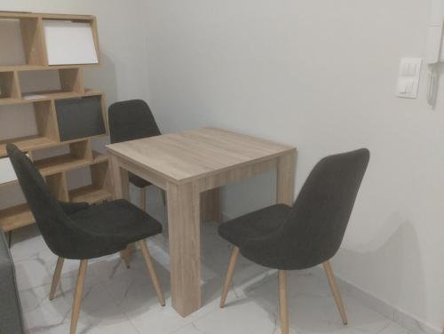 een houten tafel met vier stoelen en een tafel en een plank bij Peggy's Superior Apartment in Kateríni
