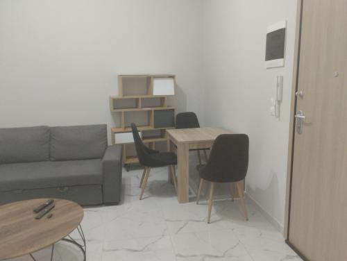 een woonkamer met een bank en een tafel en stoelen bij Peggy's Superior Apartment in Kateríni