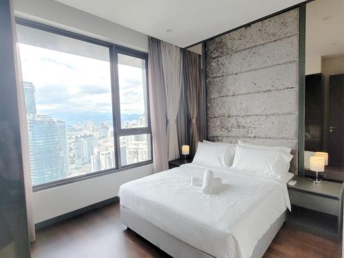 um quarto com uma cama branca e uma grande janela em 8 Kia Peng Suites Residence em Kuala Lumpur