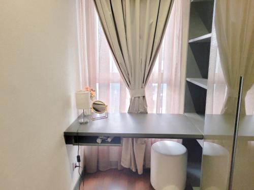a desk in front of a window with a curtain at 8 Kia Peng Suites Residence in Kuala Lumpur