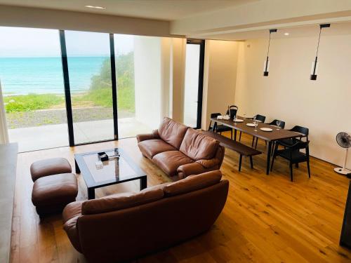 a living room with a couch and a table at Beach front studio -NagoNago- in Nago