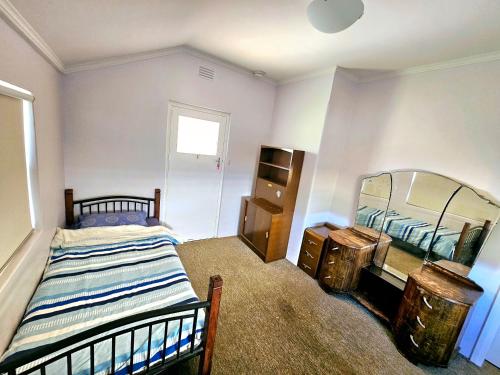 a bedroom with a bed and a mirror at Spacious Holiday Home-Ramco in Waikerie