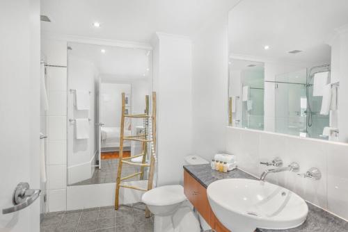 uma casa de banho com um lavatório, um WC e um espelho. em Belle Escapes Sapphire Suite Oceanview 17 Alamanda Palm Cove em Palm Cove