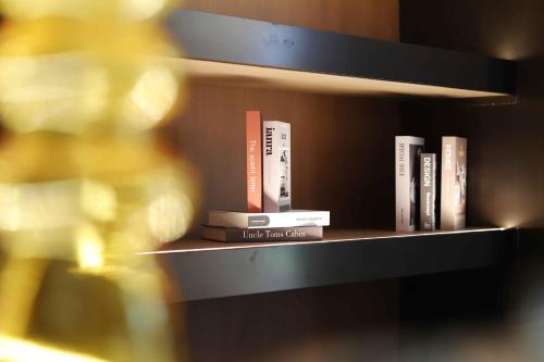 a shelf filled with books and a bottle of wine at Pullman Haikou in Haikou