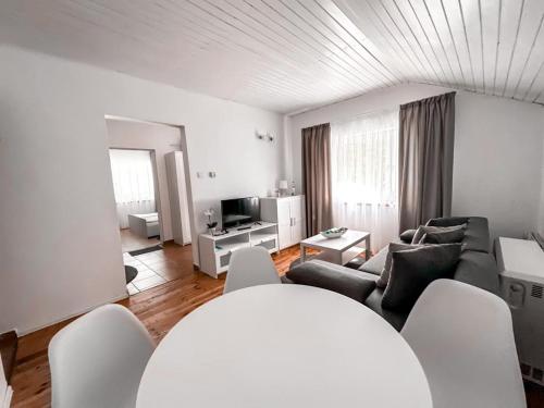 a living room with a couch and a tv at Summer House in Lubniewice