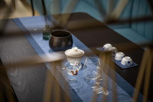 a table with wine glasses and a vase on it at Dijing Hotel Shanghai in Shanghai