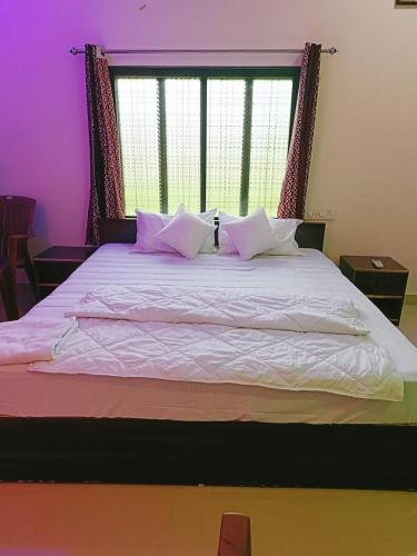 a large bed with pink pillows and a window at The Mountain View Home Stay in Khajurāho