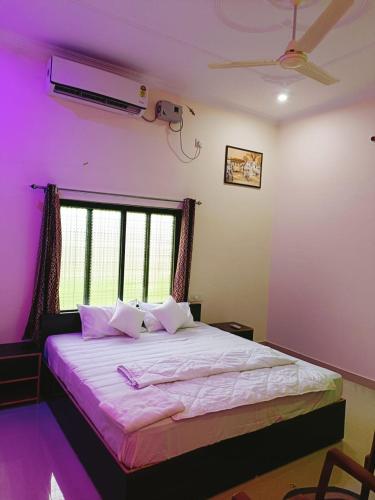 a bedroom with a large bed with purple walls at The Mountain View Home Stay in Khajurāho
