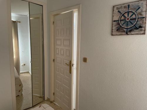 Puerta de baño con espejo junto a la habitación en Apartamento playa-Piscina-Wifi gratis, en Denia
