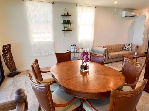 - un salon avec une table et des chaises en bois dans l'établissement Hummingbird Oceanfront Cottage, à Hauula
