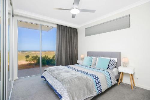 um quarto com uma cama e uma grande janela em Executive Accommodation Absolute Beach Front em Middleton