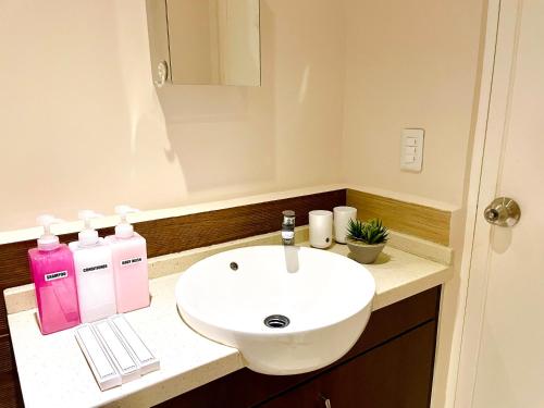 a bathroom with a white sink and a mirror at Studio Type - Matina Enclaves Residences in Davao City