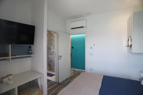 a room with a bed and a desk and a television at Montebello Luxury Apartment in Peschici