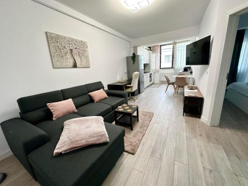 a living room with a green couch and a living room with a table at Angela Nordic apartment. in Suceava