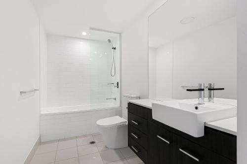a bathroom with a sink and a toilet and a shower at Harbour Quays Apartments in Gold Coast