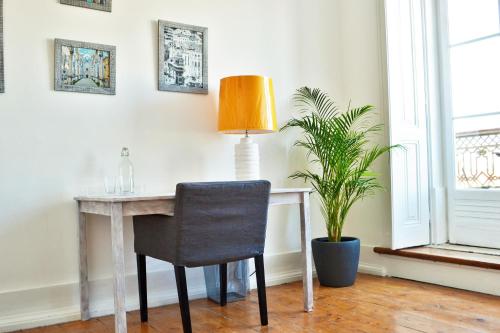 a desk with a chair and a lamp in a room at Feeling Chiado 15 in Lisbon