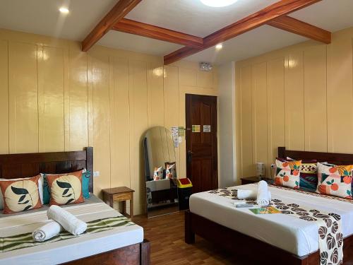 a bedroom with two beds and a room with at MANANQUIL TRAVEL LODGE in El Nido