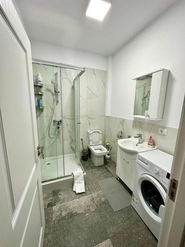 a bathroom with a shower and a toilet and a sink at Angela Nordic apartment. in Suceava