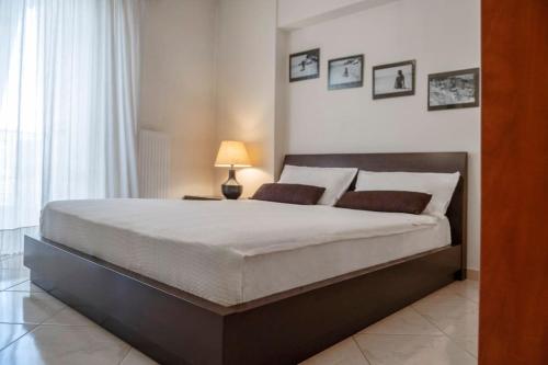 1 dormitorio con 1 cama grande y 1 lámpara en Lovely home apt with private parking next to Metro, en Atenas